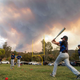 Little League players warm up before a game as the Valley Fire burns in the background near San Diego.